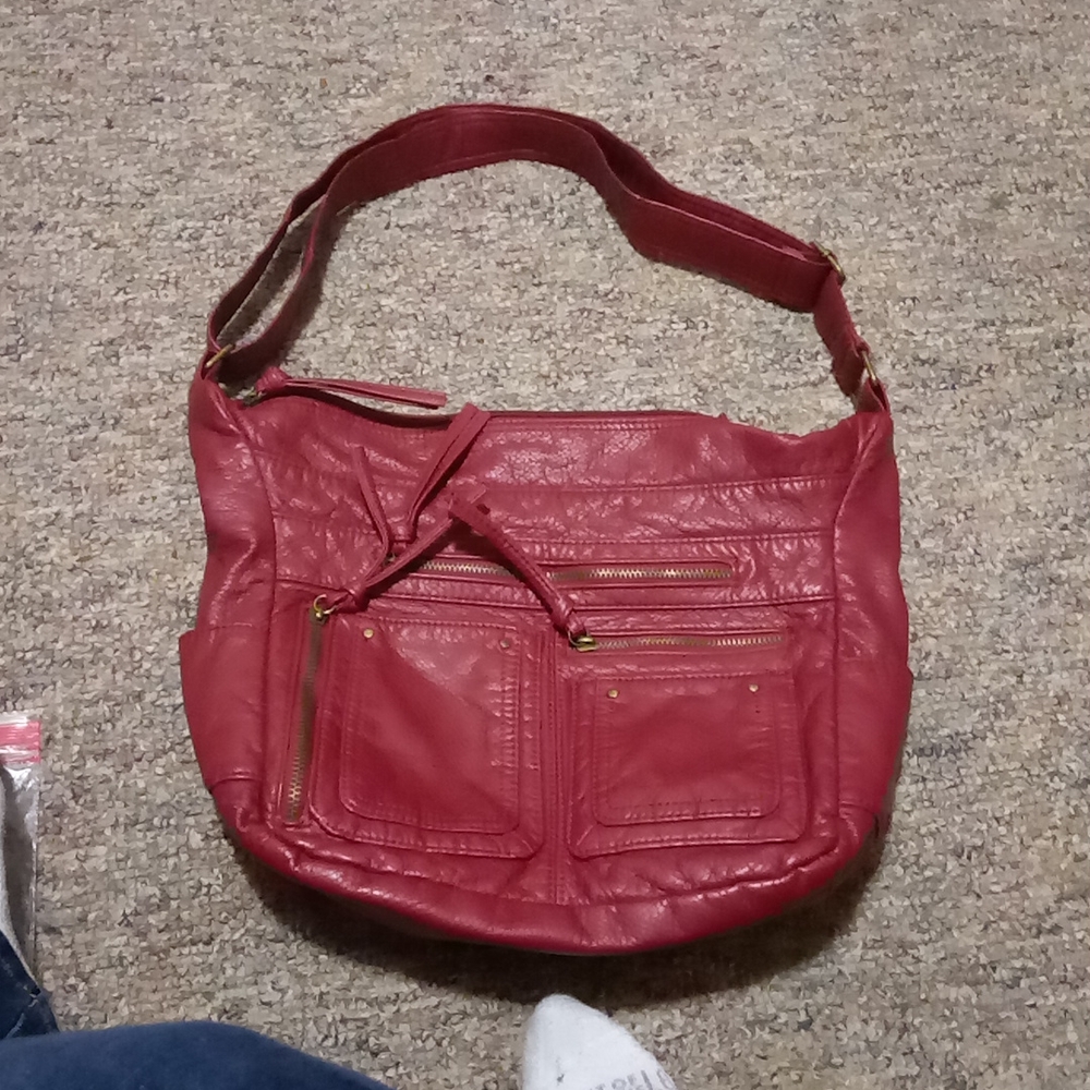 Large handbag no label.  Made in China. Burgendy color. Lots of departments.